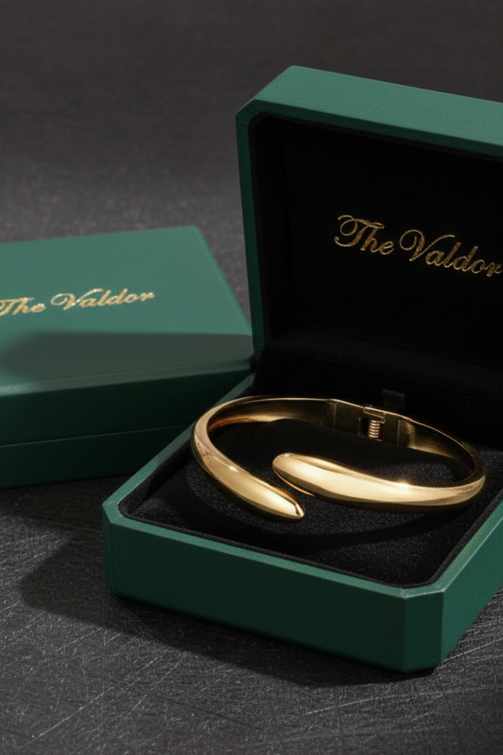 Gold bracelet in a green 'The Valdor' box on a dark surface