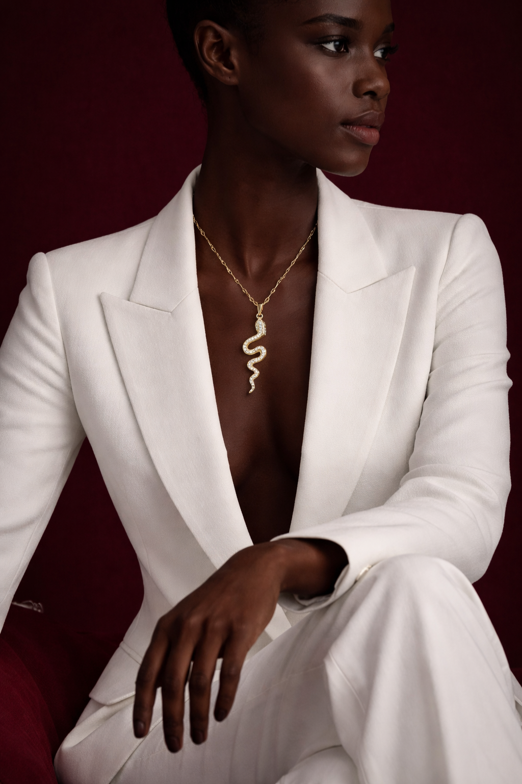 Side view of the Valdor Ophia snake necklace, showcasing its sculptural gold design and brilliant zirconia stone detailing.