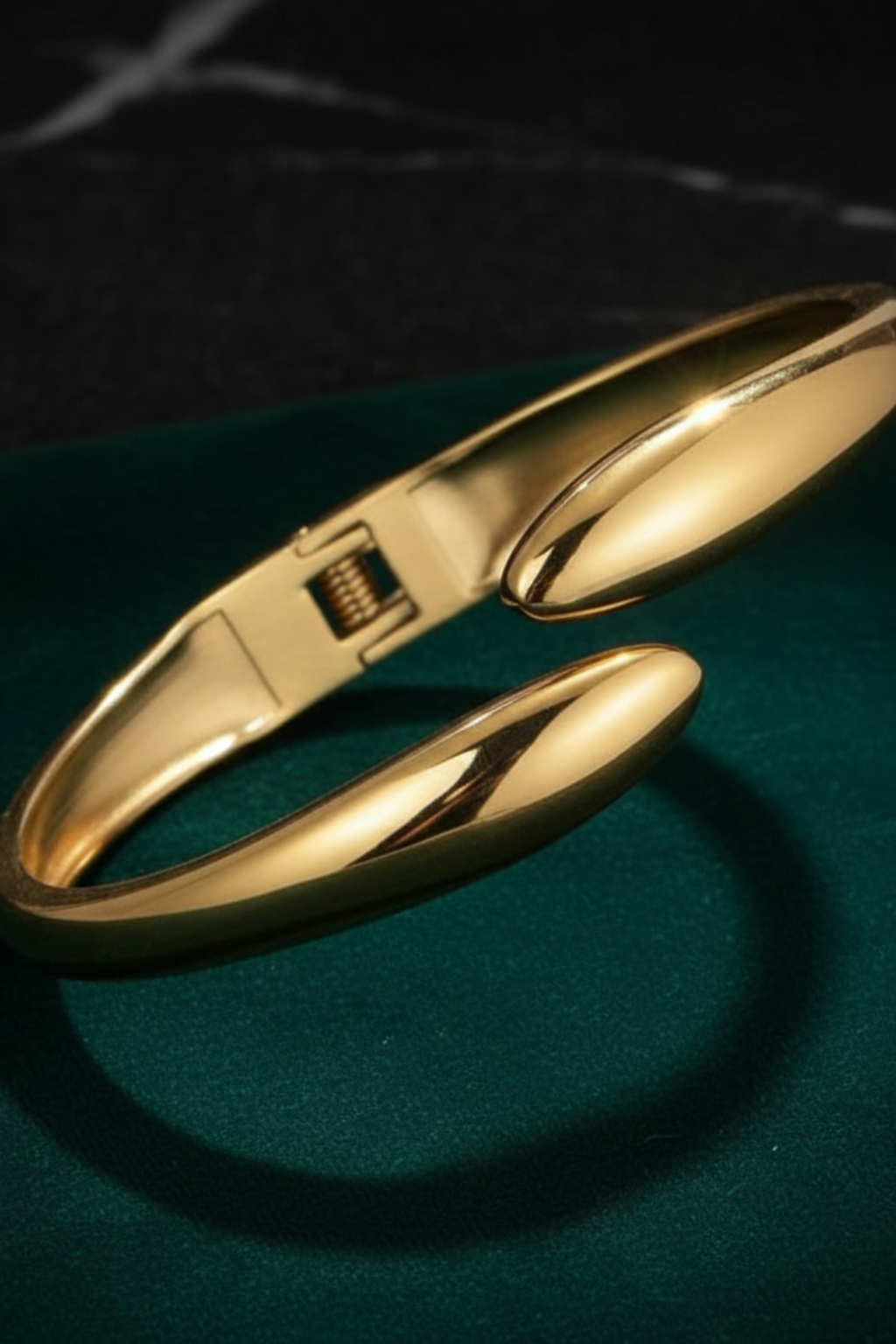 Gold bracelet on a dark green surface