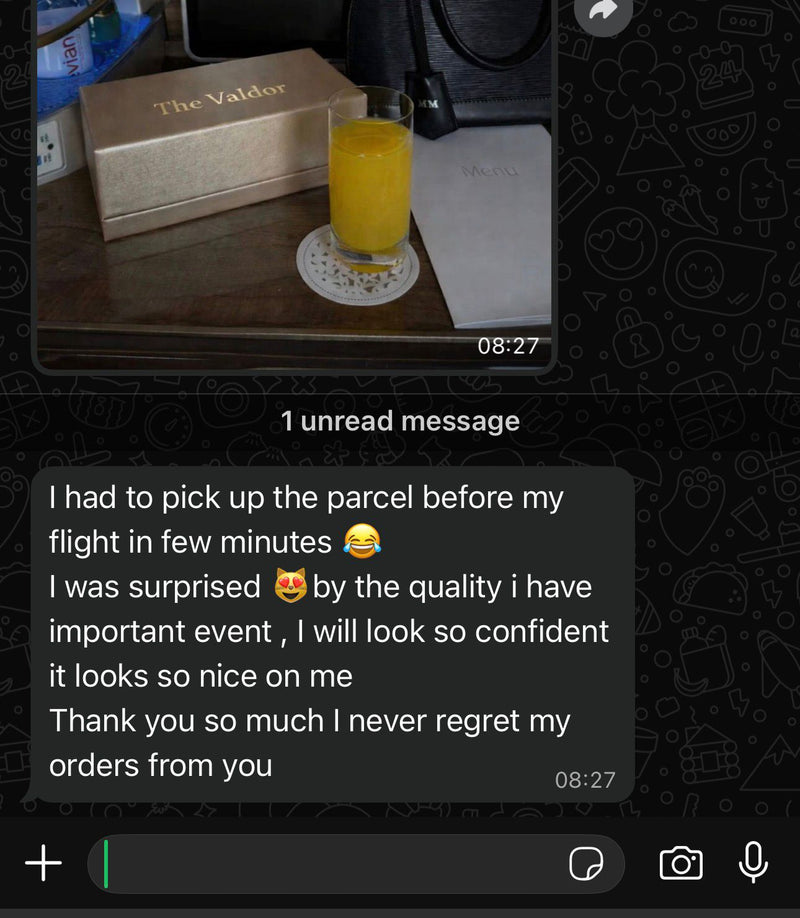 Glass of orange juice on a coaster with a text message notification on a smartphone screen.